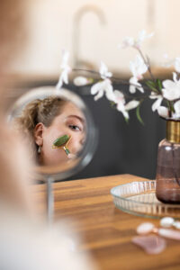 woman applying self care product on her face